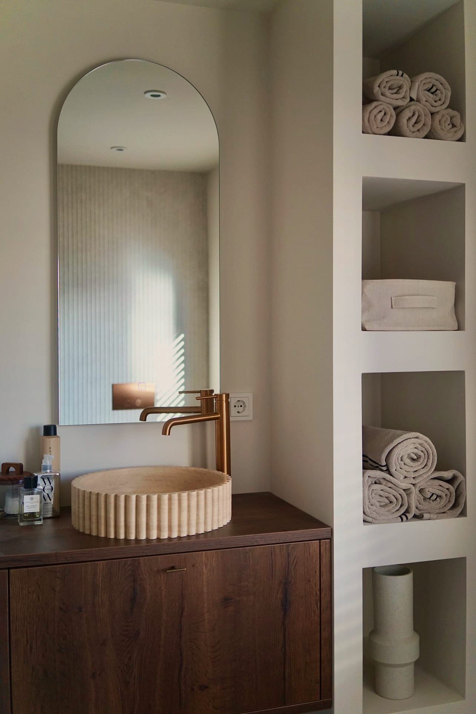 Travertin waskom in een warme badkamer
